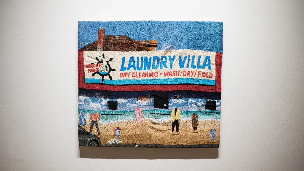 embroidered tapestry featuring a laundromat exterior