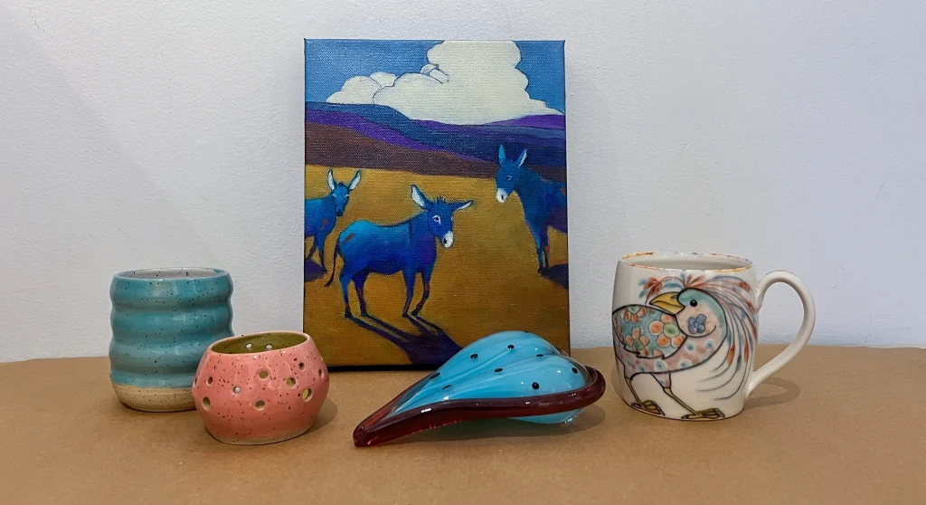 A gathering of items from the AGP Gallery Shop including ceramics, glass, and a painting