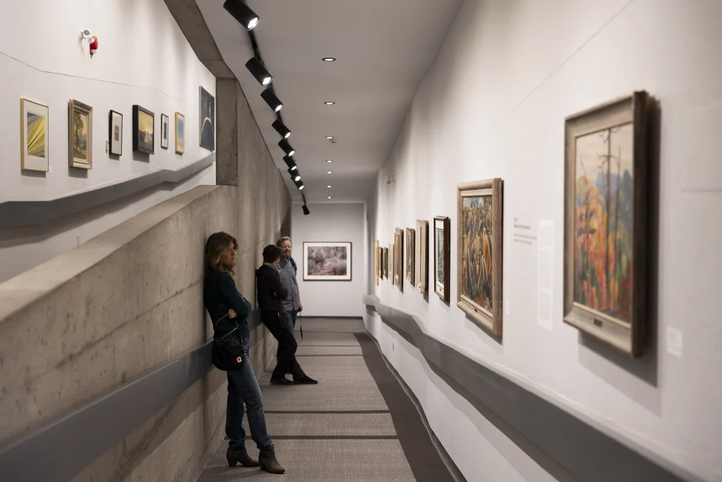 People view an exhibition from the Permanent Collection in the ramp galleries at the Art Gallery of Peterborough