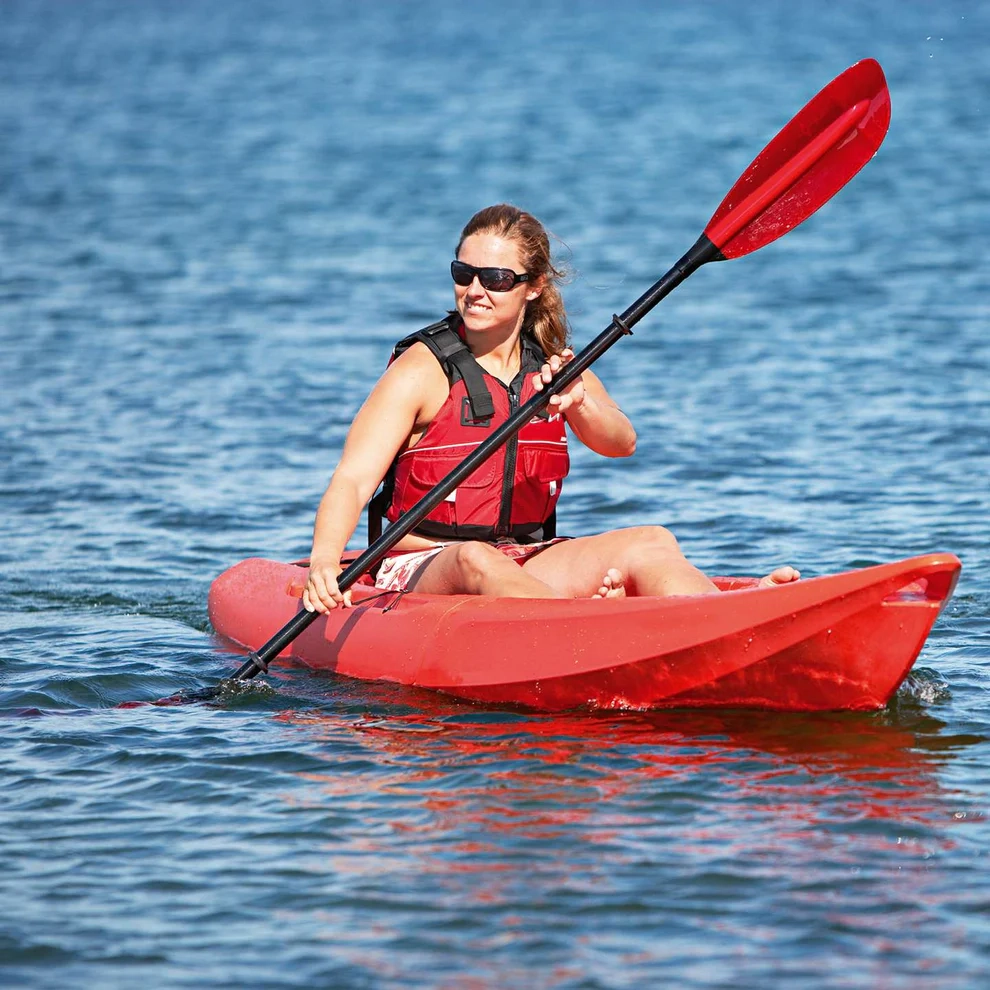 a person wearing a lifejacket and kayaking on smooth water