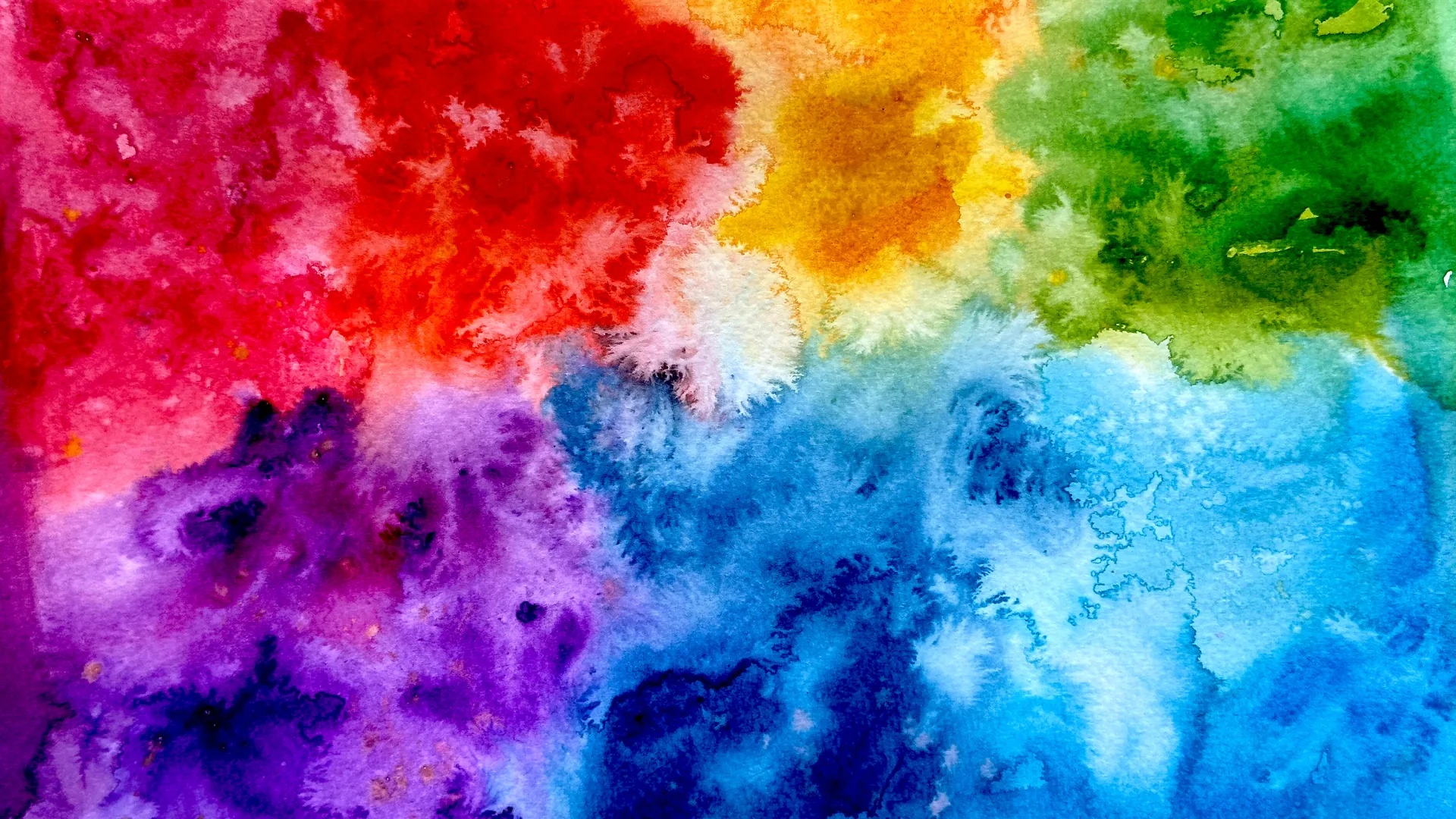 Abstract watercolor painting with vibrant splashes of red, yellow, green, blue, and purple blending together across the canvas.
