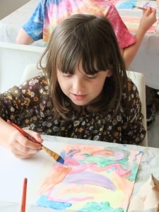 Child painting during an AGP camp