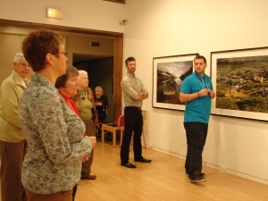 Group of adults viewing art installed in AGP's main gallery during a seniors tour
