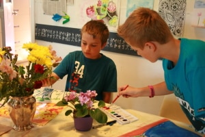 Two children painting flowers during a PA Day camp at AGP