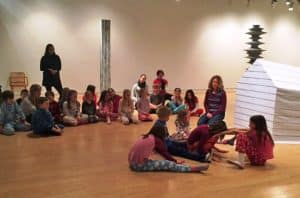 School group sitting in AGP's main gallery surrounded by Lyn Carter's sculptures. Three dimensional fabric sculptures with wooden armatures.