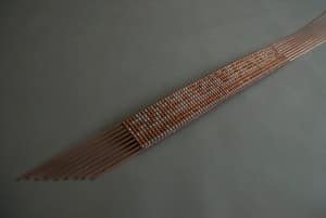 Copper and aluminum weaved sculpture by Michael Belmore. Metal weaved together creating a bead like belt/