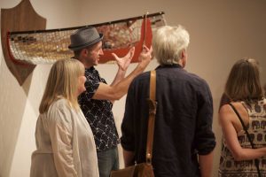 Group of people viewing artwork installed in AGP's main gallery