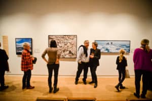 Group of people viewing Roberta Bondar's artworks installed in AGP's main gallery