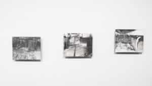 Gallery view of Sasha Opeiko's solo exhibition 217. Three graphite drawings on gessoed aluminum featuring a dilapidated nuclear building installed on the AGP ramps.