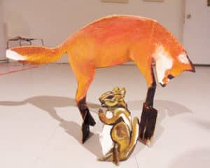 Three dimensional paper collage of a red fox jumping over a brown a three dimensional paper collage of a brown and white chipmunk