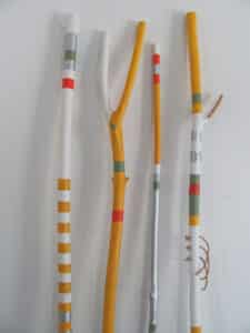 Carved and painted walking sticks by John Boorman featuring red, silver, white, yellow, and green