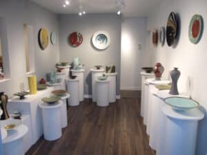 Bill Reddick's studio featuring various ceramic works on the wall and on plinths