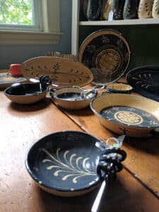 Various handmade dishes sitting on a wooden tale in Suzanne Woods' studio