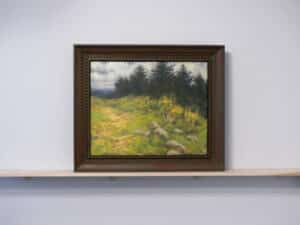 Framed oil painting by Steven Vero sitting on a wooden ledge installed on the AGP ramps