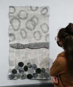 Person on the right looking at a textile artwork installed on the AGP ramps