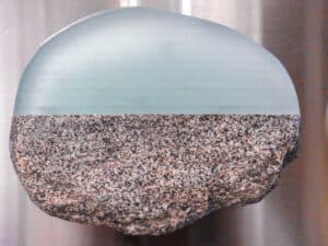 Detail of Christy Haldane's wall mounted sculpture, stone fuzed with reclaimed glass creating a rock sized oval