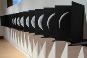 acrodion style bookwork in black that depicts each phase of the moon