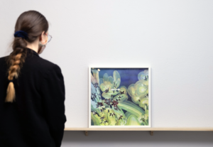 person viewing a painting in a gallery of flowers with warm gradations and a blue background.