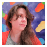 Caucasian female with long brown hair, wearing a black striped shirt and orange sweater, in front of a purple background with yellow, blue, green and orange blobs