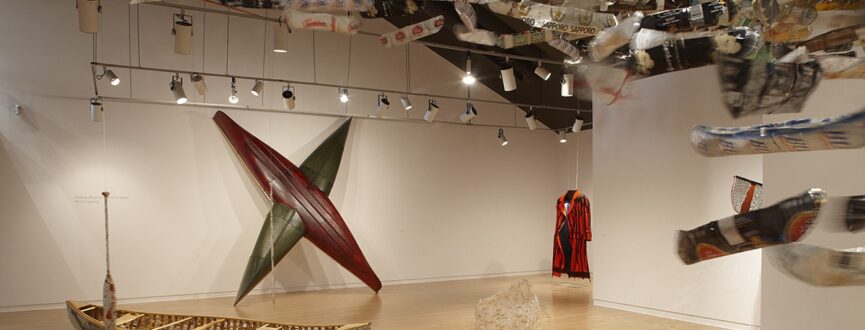 installation view of sculptural artworks made from canoes in an art gallery