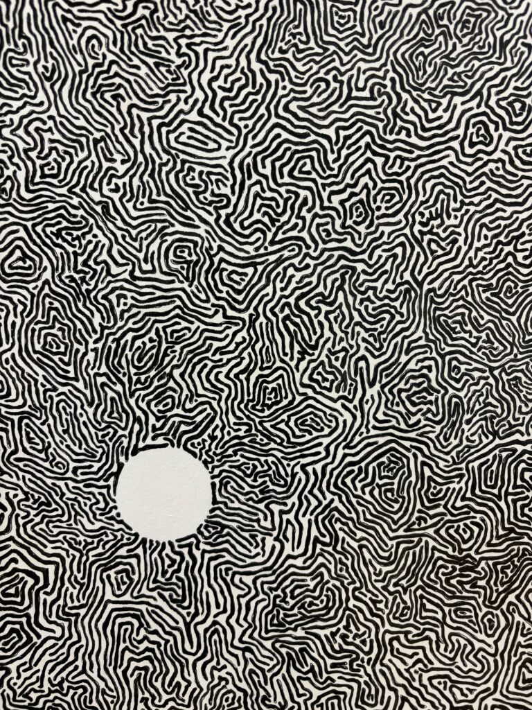 An abstract line piece; black “maze-like” lines cover all but one circle, which is left as negative space.